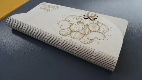 Close up view of a laser cut living hinge on a wooden envelope showcasing precise parallel micro cuts.