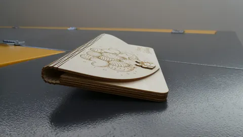 Side profile of a curved wooden gift envelope showcasing three layer plywood construction and a flush clasp.