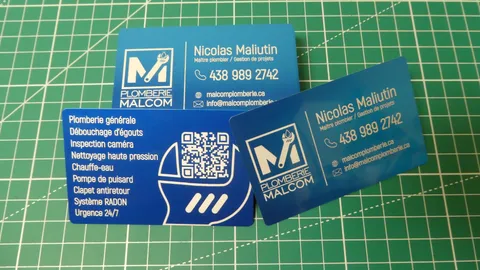 Laser engraved blue aluminum business cards displaying custom plumbing logo and crisp typography.