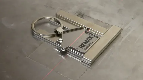 Macro video of a precision laser engraving process on a custom keychain. The video demonstrates the high-speed marking of intricate logos and text, showcasing the industrial fabrication capabilities of TechArt Concept.