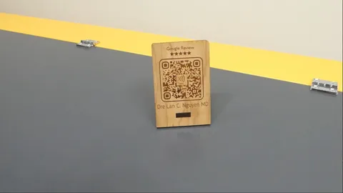Laser engraved wooden Google review stand being scanned by smartphone to launch local business review page.